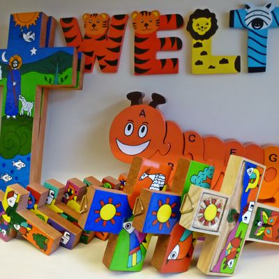 Bild vergr&ouml;&szlig;ern: Bunte Kinderkreuze und eine Holzraupe