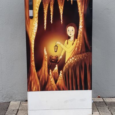 Bild vergr&ouml;&szlig;ern: M�dchen in einer Tropfsteinh�hle mit Teddy und Lampe in der Hand