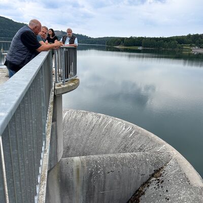 Bild vergr&ouml;&szlig;ern: Mehrere Personen schauen von oben in den �berlauf des Biggesees.