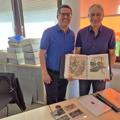 Bild vergr&ouml;&szlig;ern: Zwei M�nner mit Zeichnungen in einem B�ro.