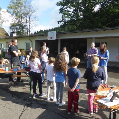 Bild vergr&ouml;&szlig;ern: Kinder stehen in einer Reihe und h�ren aufmerksam zu