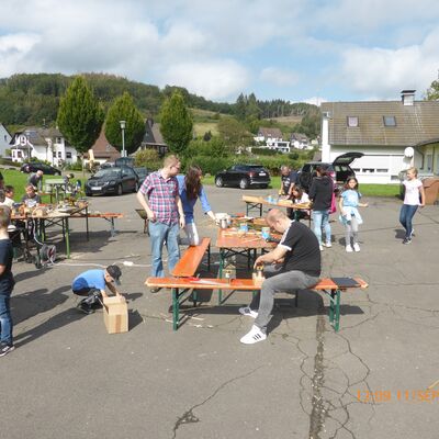 Bild vergr&ouml;&szlig;ern: Kinder und Erwachsene sitzen und machen eine Pause