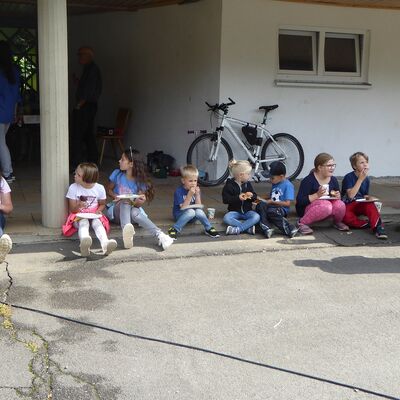 Bild vergr&ouml;&szlig;ern: Kinder sitzen, essen und trinken