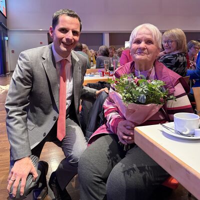 Bild vergr&ouml;&szlig;ern: Mann und Seniorin mit Blumenstrau�