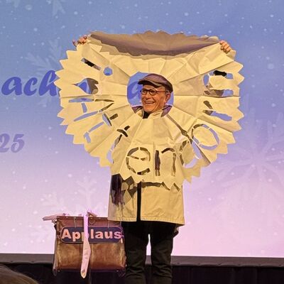 Bild vergr&ouml;&szlig;ern: Ein Mann auf einer B�hne mit einem sehr gro�en Papierstern