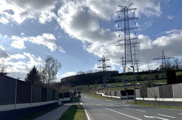 Stra�e mit Hochspannungsmasten im Hintergrund