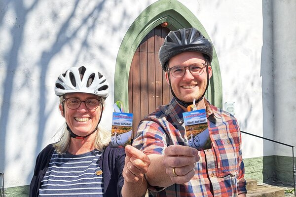 Bild vergr&ouml;&szlig;ern: Zwei Menschen tragen einen Fahrradhelm.